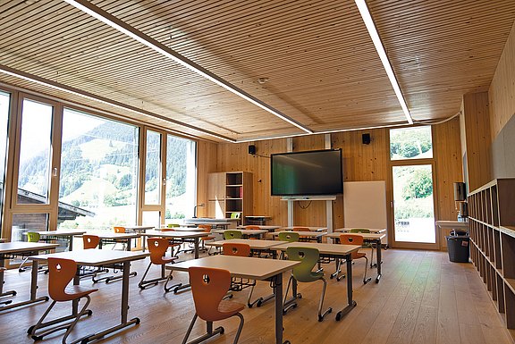 Abbildung eines Klassenzimmers in Holzbauweise mit vielen großen Fenstern
