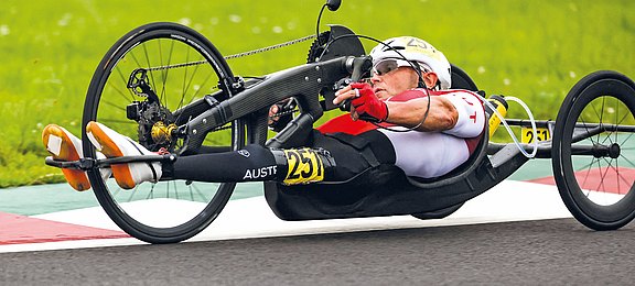 Walter Ablinger auf seinem Speed-Handbike liegend auf einer Rennstrecke bei einem Wettkampf 